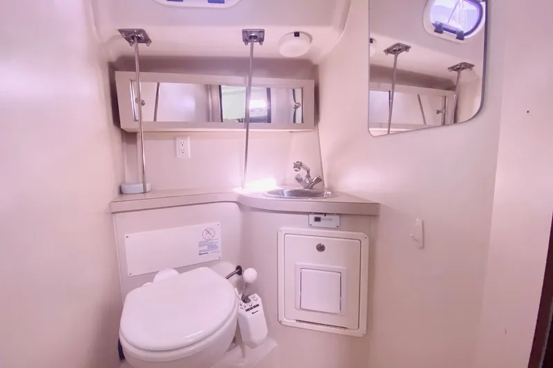 Slide: The Image of Compact bathroom in a 2007 Catalina 309 sailboat with sink, toilet, and mirror. - 23