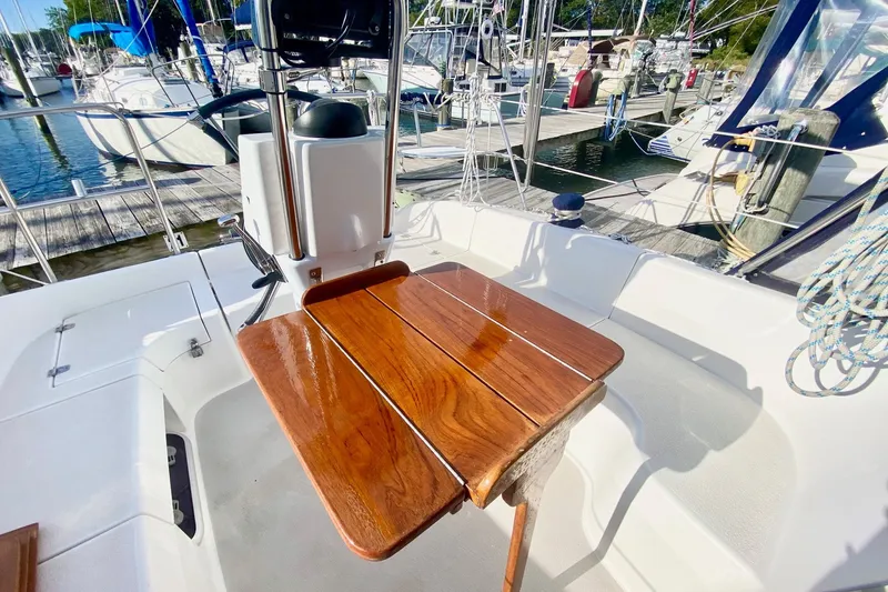 Slide: The Image of Cockpit of a 2007 Catalina 309 sailboat with wooden table and marina view. - 57