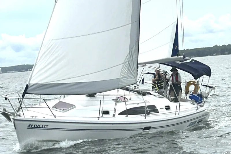 Slide: The Image of 2007 Catalina 309 sailboat navigating on a breezy day with passengers onboard. - 1