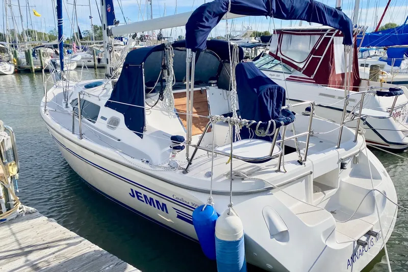 Slide: The Image of Sailboat Catalina 309, 2007 model, docked in a marina with blue covers. - 5