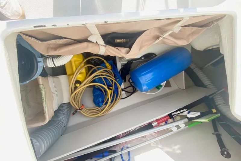 Slide: The Image of Storage compartment in a 2007 Catalina 309 sailboat with various boating equipment. - 58