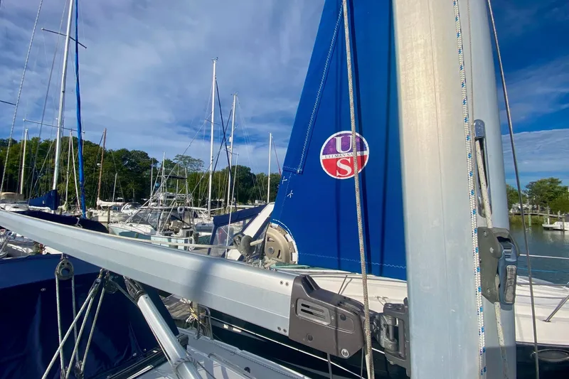 Slide: The Image of Sailboat Catalina 309, 2007 model, docked with blue sail and clear sky background. - 47