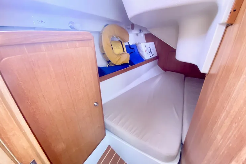 Slide: The Image of Cozy cabin interior of 2007 Catalina 309 sailboat with wooden finish and life preserver. - 32