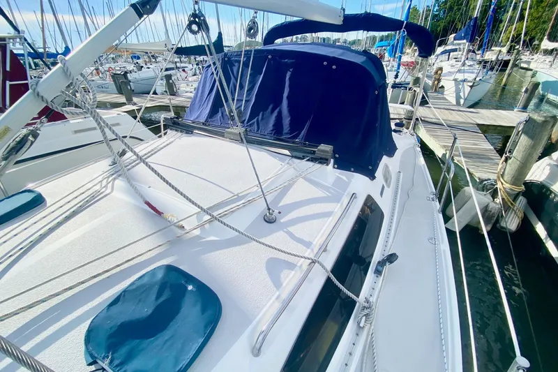 Slide: The Image of 2007 Catalina 309 sailboat docked at marina, featuring blue canvas cover and rigging. - 49