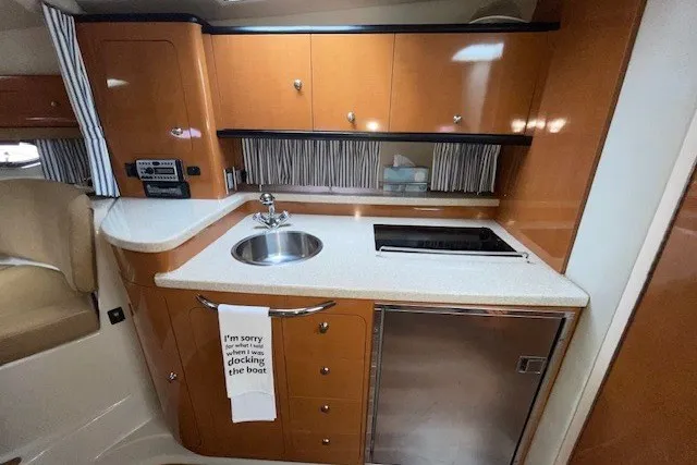 Slide: The Image of 2007 Chaparral Signature 330 yacht kitchen with sink, stove, and wooden cabinetry. - 10