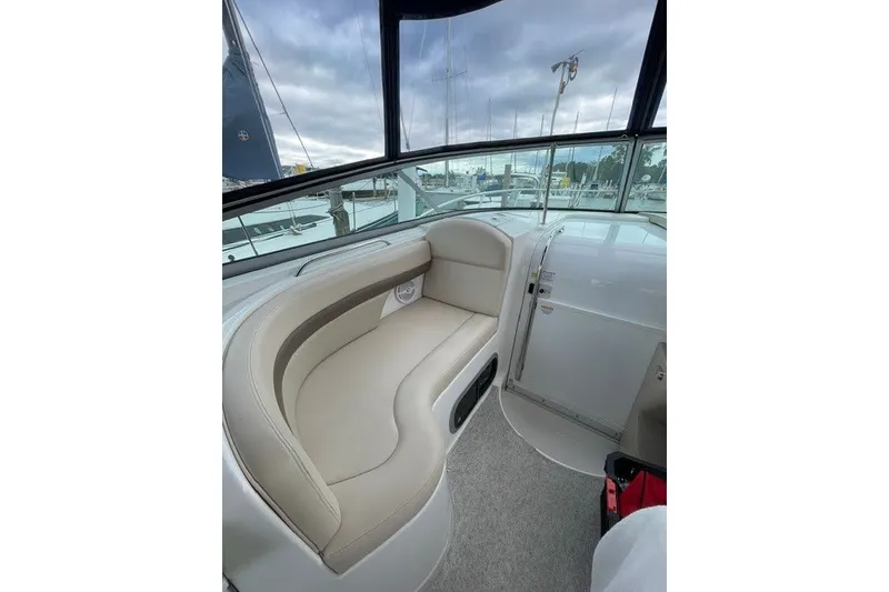 Slide: The Image of 2007 Chaparral Signature 330 boat interior with beige seating and marina view. - 8