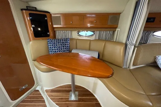 Slide: The Image of 2007 Chaparral Signature 330 cabin interior with leather seating and wooden table. - 9