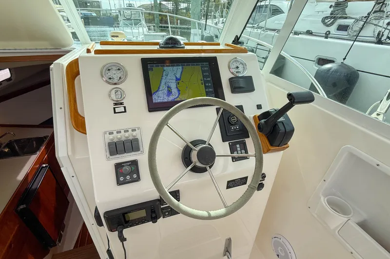 Slide: The Image of Helm of 2004 Hunt Yachts Surfhunter 29 with navigation display and controls. - 11