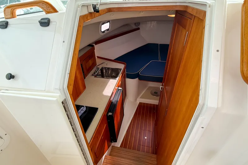 Slide: The Image of 2004 Hunt Yachts Surfhunter 29 cabin interior with kitchenette and seating area. - 14