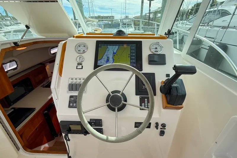 Slide: The Image of Helm of 2004 Hunt Yachts Surfhunter 29 with navigation display and controls. - 12