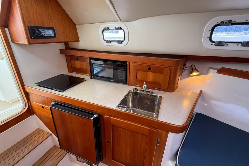 Slide: The Image of 2004 Hunt Yachts Surfhunter 29 interior kitchen with stove, sink, and microwave. - 16