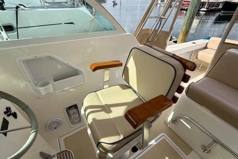 Slide: The Image of Captain's chair on 2004 Hunt Yachts Surfhunter 29, featuring wood accents and beige upholstery. - 10