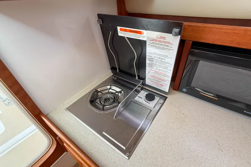 Slide: The Image of Compact galley stove in 2004 Hunt Yachts Surfhunter 29, featuring a single burner and safety instructions. - 17