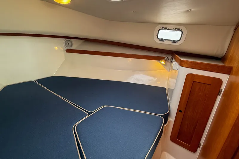 Slide: The Image of 2004 Hunt Yachts Surfhunter 29 cabin interior with blue cushions and wooden accents. - 21