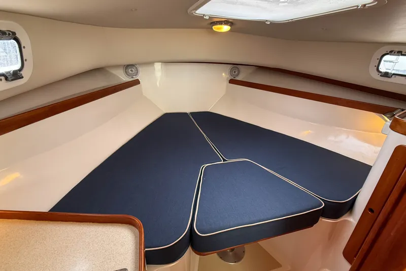 Slide: The Image of 2004 Hunt Yachts Surfhunter 29 cabin interior with blue cushions and wood accents. - 19