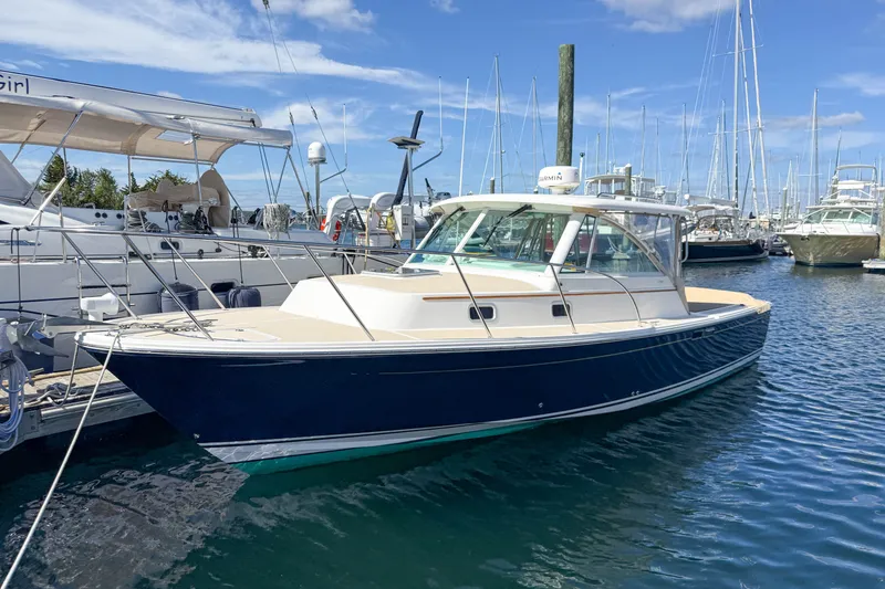 The Image of 2004 Hunt Yachts Surfhunter 29 docked in a marina under a clear blue sky. - 0
