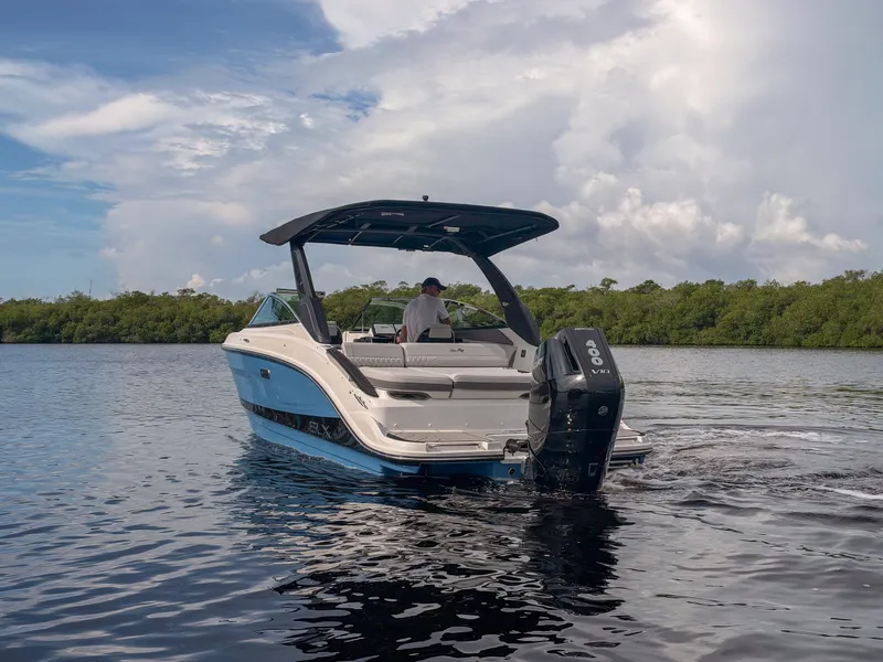Slide: The Image of A 2027 Sea Ray SLX 260 Outboard cruising on calm waters under a cloudy sky. - 26