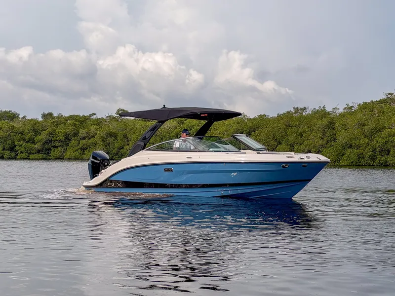 Slide: The Image of A blue and white 2027 Sea Ray SLX 260 Outboard cruising on calm waters. - 22