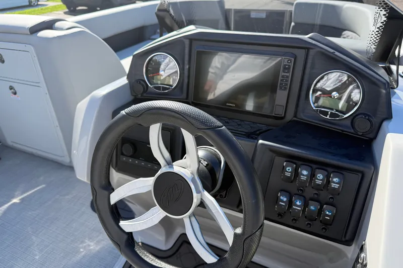 Slide: The Image of Steering console of 2027 Manitou Encore 25 RF Dual boat with modern controls. - 14