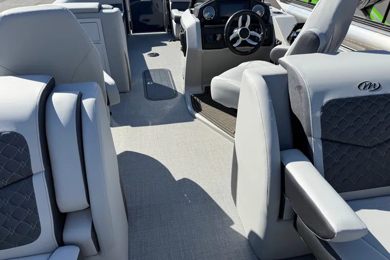 Slide: The Image of Interior of 2027 Manitou Encore 25 RF Dual pontoon boat with luxurious seating and modern dashboard. - 21