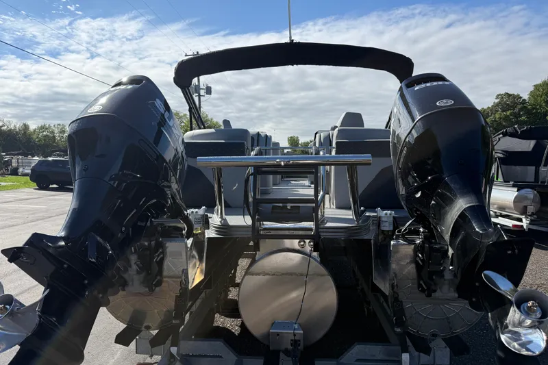 Slide: The Image of 2027 Manitou Encore 25 RF Dual pontoon boat with dual engines, parked outdoors. - 1