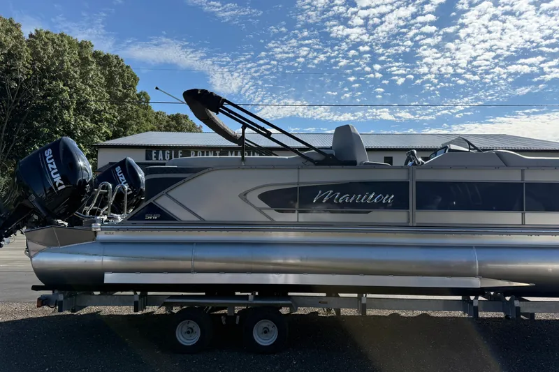 Slide: The Image of 2027 Manitou Encore 25 RF Dual pontoon boat with Suzuki engines on a trailer. - 4