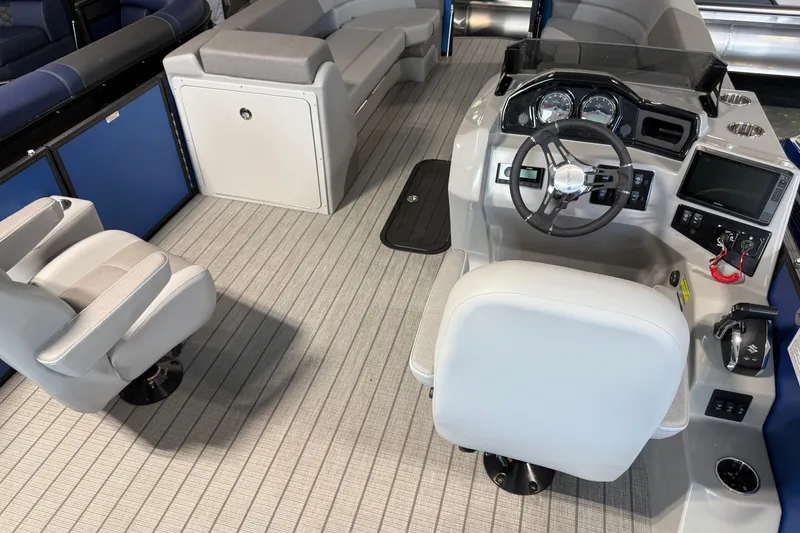 Slide: The Image of 2027 Manitou Encore SL 25 boat interior with steering console and seating. - 24