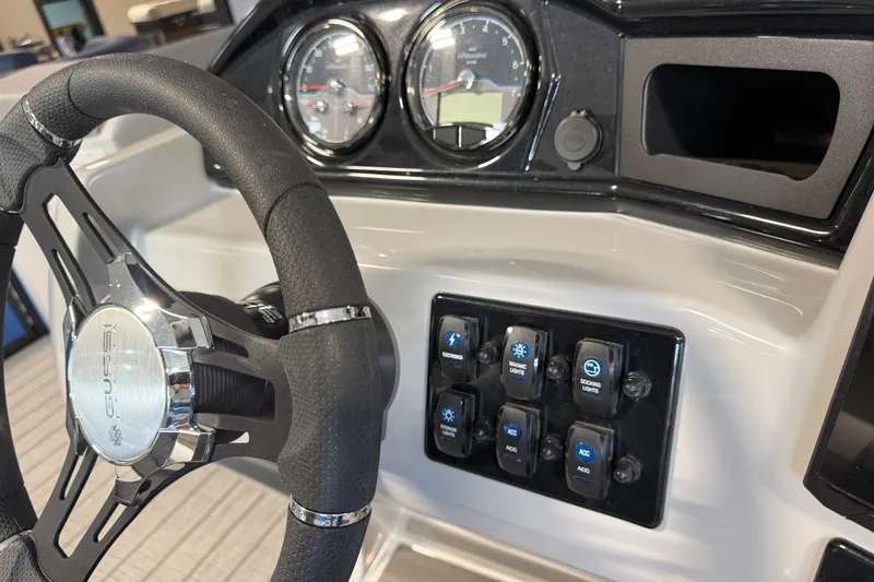 Slide: The Image of Steering wheel and dashboard controls of 2027 Manitou Encore SL 25 boat. - 21