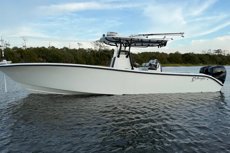 Slide: The Image of 2018 Yellowfin 32 Offshore boat on calm water, featuring sleek design and dual engines. - 4