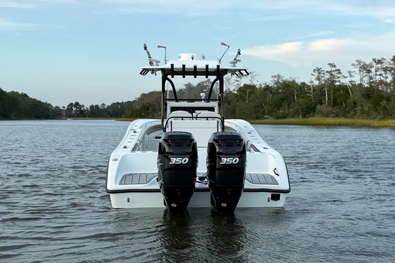 Slide: The Image of 2018 Yellowfin 32 Offshore boat with dual 350 horsepower engines on a calm river. - 2
