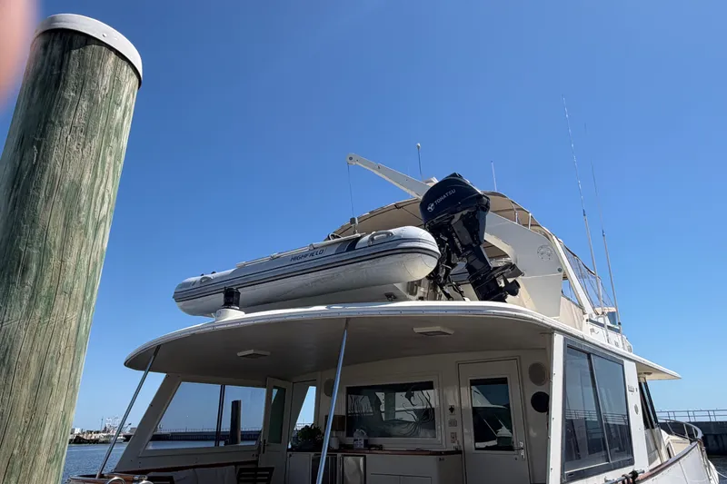 Slide: The Image of 1986 Hatteras 58 Motor Yacht docked with inflatable boat on top deck. - 16