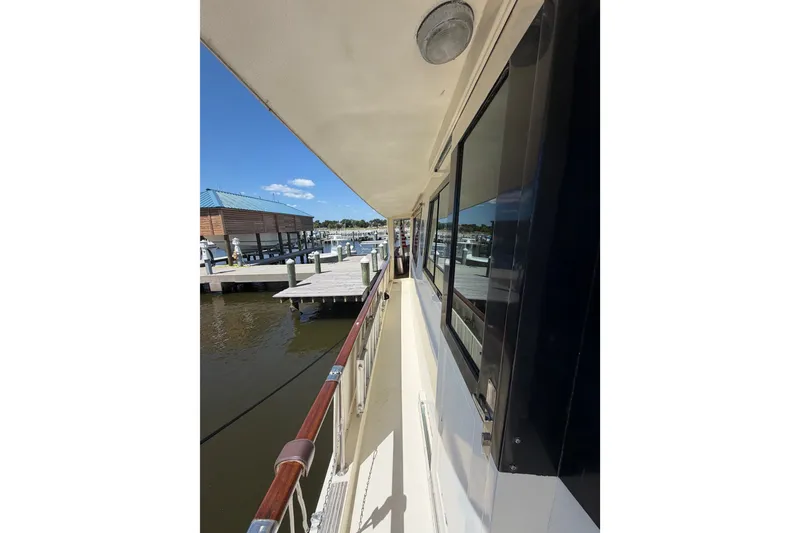 Slide: The Image of Side view of 1986 Hatteras 58 Motor Yacht docked at marina. - 13