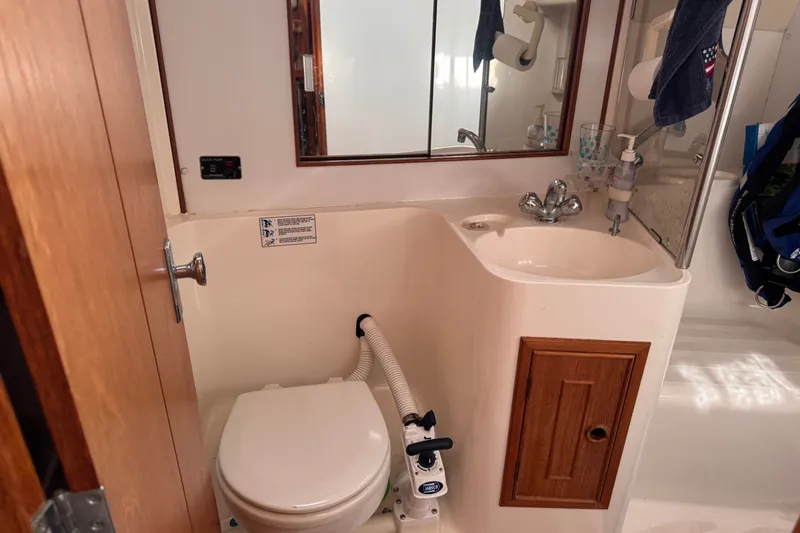 Slide: The Image of Compact boat bathroom with toilet, sink, and mirror in a 1991 CS 34 model. - 30