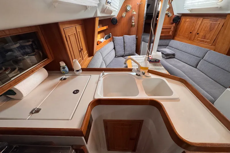 Slide: The Image of Interior of a 1991 CS 34 sailboat featuring a cozy seating area and compact kitchen. - 20