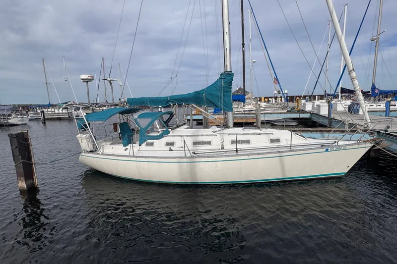 The Image of Sailboat docked at marina, 1991 CS 34 model, with blue canopy and calm waters. - 0