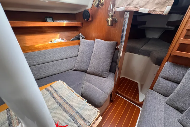 Slide: The Image of Cozy interior of a 1991 CS 34 sailboat with plush seating and wooden accents. - 24
