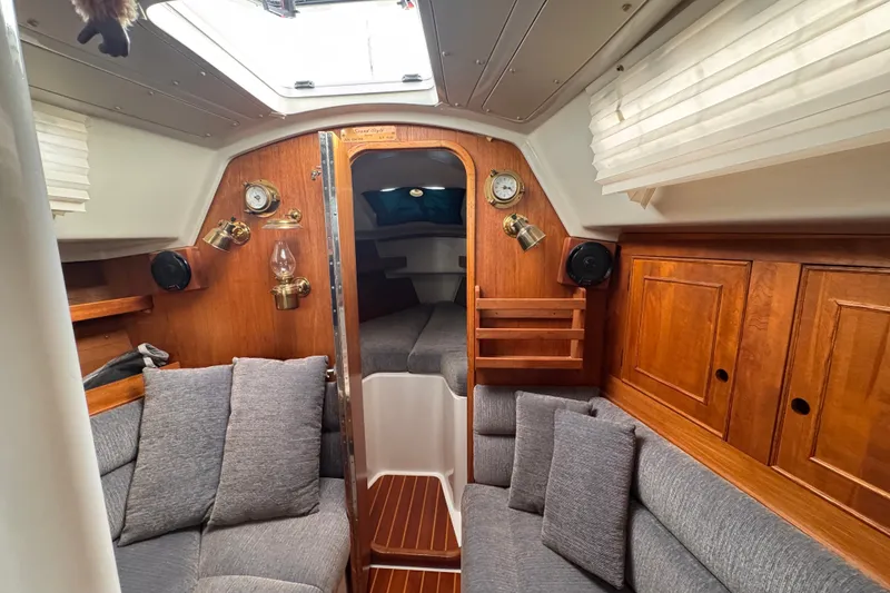 Slide: The Image of Cozy 1991 CS 34 sailboat interior with wood paneling and gray seating. - 22