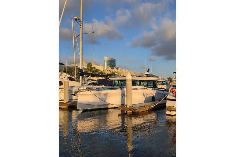 Slide: The Image of 2024 Axopar 45 XC Cross Cabin docked at marina under blue sky. - 29