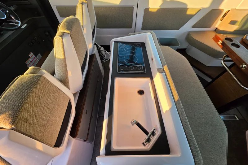 Slide: The Image of 2024 Axopar 45 XC Cross Cabin interior with seating, sink, and stove. - 16