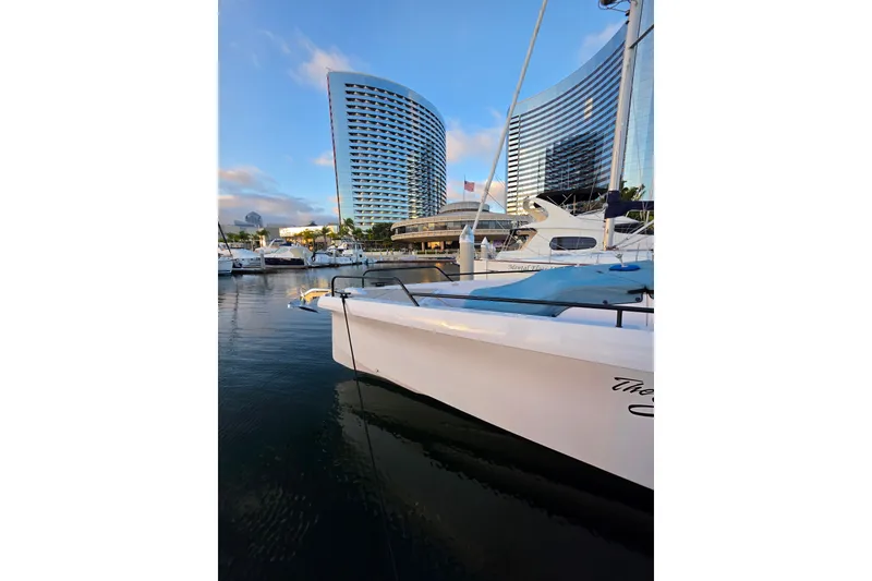 Slide: The Image of 2024 Axopar 45 XC Cross Cabin docked near modern buildings at sunset. - 25