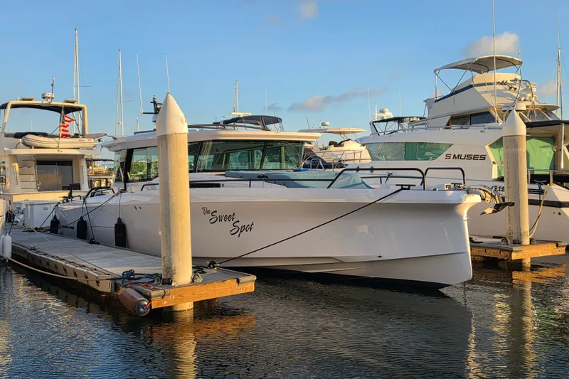 Slide: The Image of 2024 Axopar 45 XC Cross Cabin docked at marina, surrounded by other boats. - 27