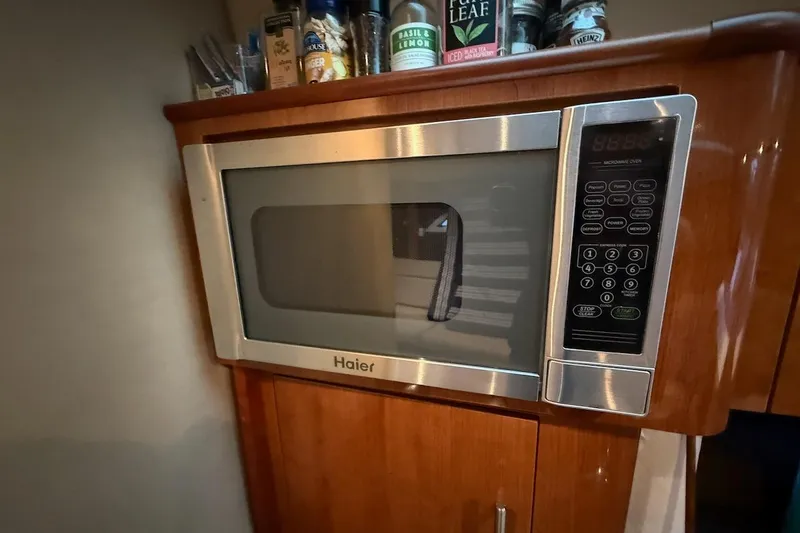 Slide: The Image of Haier microwave in 2012 Regal 35 Sport Coupe kitchen, surrounded by wooden cabinetry. - 20