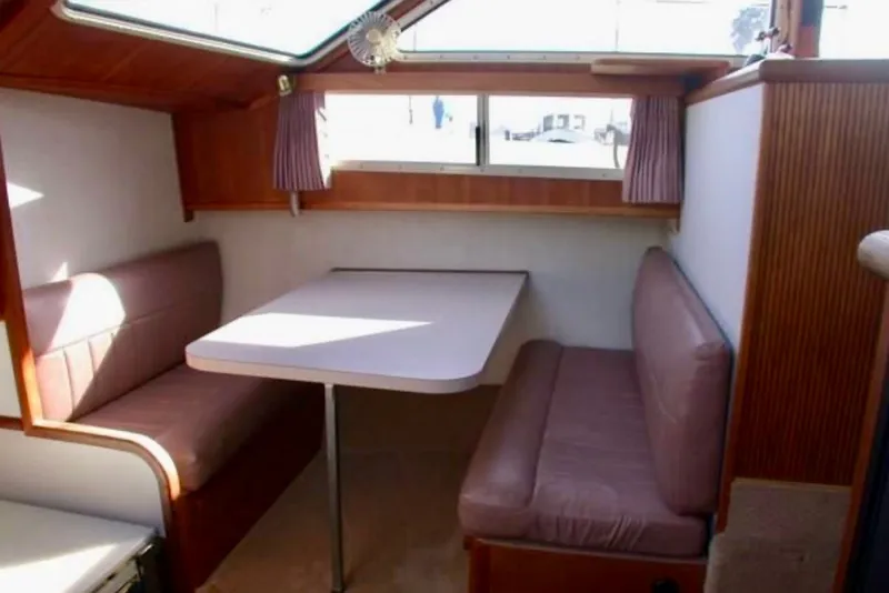 Slide: The Image of 1987 Tollycraft 44 Cockpit Motor Yacht interior with dining area and seating. - 13
