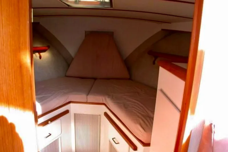 Slide: The Image of 1987 Tollycraft 44 Cockpit Motor Yacht cabin interior with cozy V-berth and wooden accents. - 14