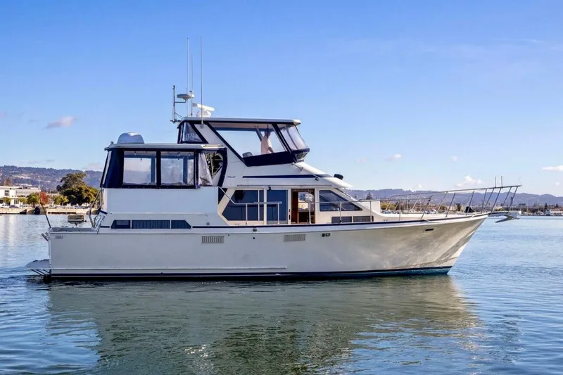 The Image of 1987 Tollycraft 44 Cockpit Motor Yacht on calm water under clear sky. - 1
