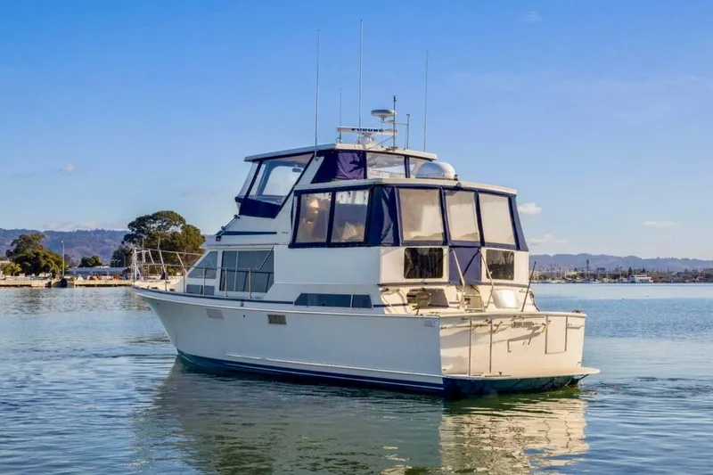 Slide: The Image of 1987 Tollycraft 44 Cockpit Motor Yacht on calm water under clear blue sky. - 2