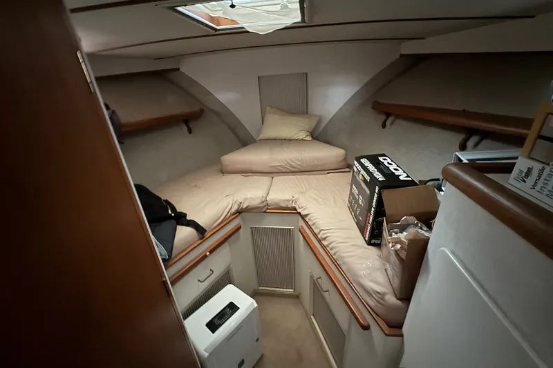 Slide: The Image of 1987 Tollycraft 44 Cockpit Motor Yacht cabin interior with cozy bedding and storage. - 11