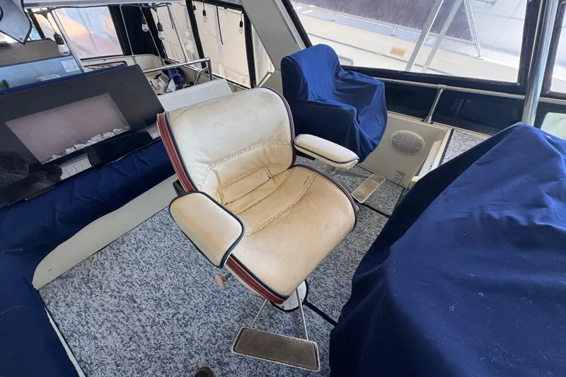 Slide: The Image of 1987 Tollycraft 44 Cockpit Motor Yacht interior with captain's chair and covered seating. - 17