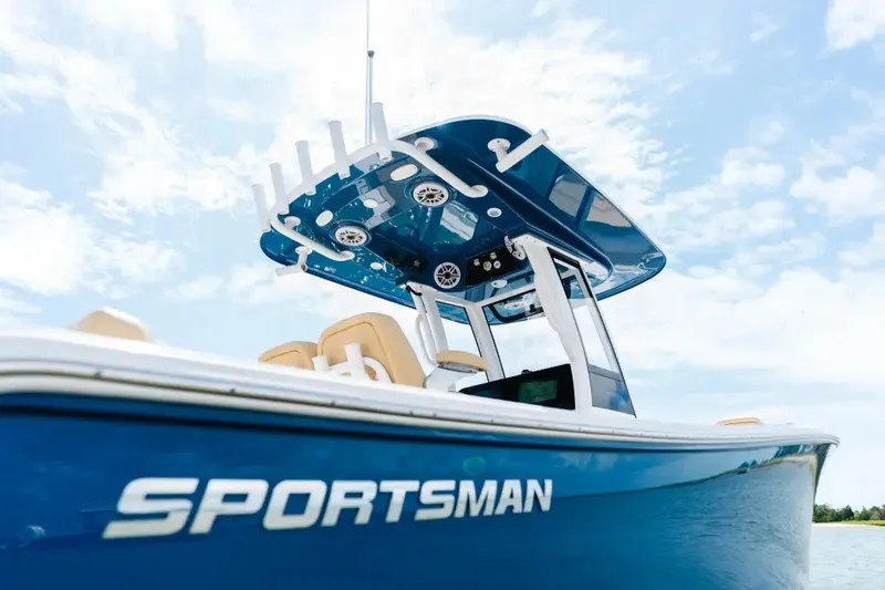 Slide: The Image of 2027 Sportsman Heritage 251 Center Console boat with blue hull under clear sky. - 9