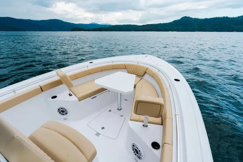 Slide: The Image of 2027 Sportsman Heritage 251 Center Console boat on a serene lake with plush seating. - 5